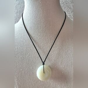 Jade donut pendant on an adjustable black cord